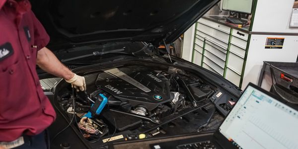 An automotive technician performing diagnostics on a BMW at The Import Mechanics in Denver, CO.